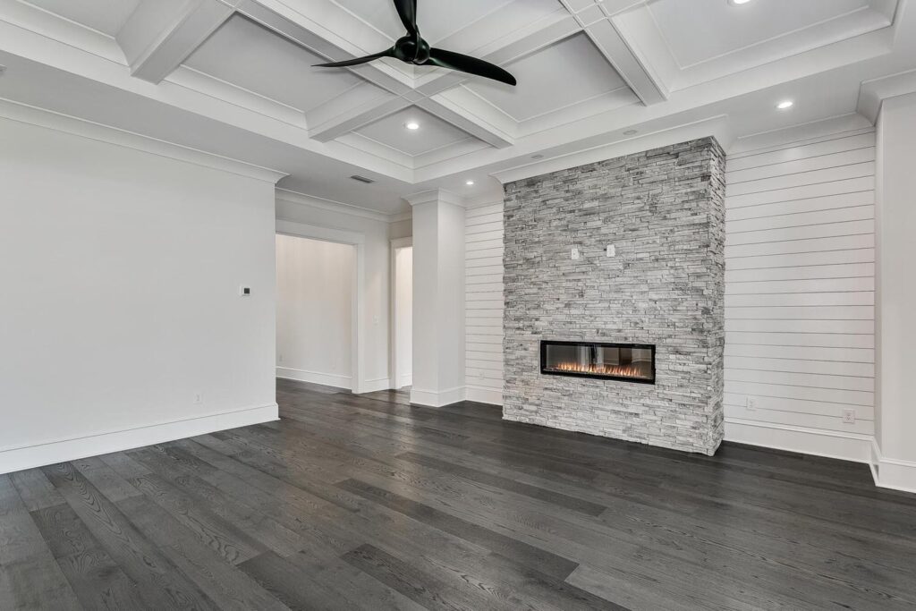 An upscale living room with a built-in fireplace and a coffered ceiling